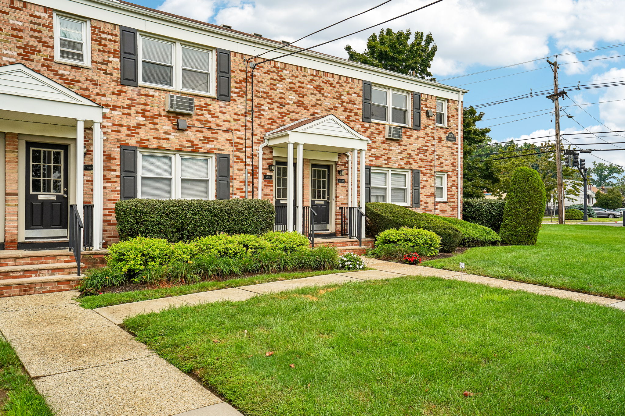 A brick house with a green lawn in front.